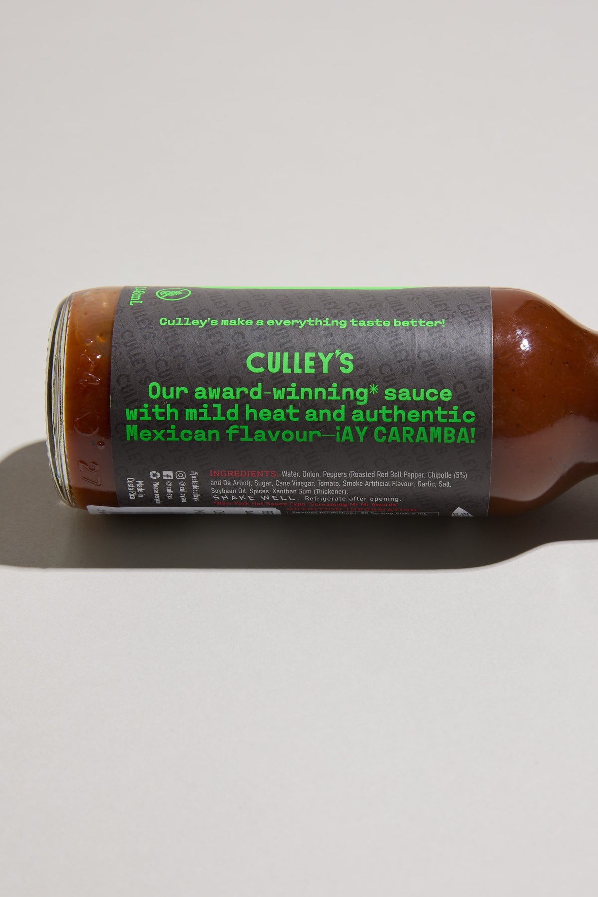 Culley’s Cheeky Chipotle Hot Sauce bottle with green text, on its side on a light surface.